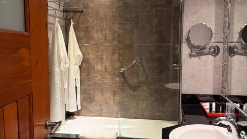 a bathroom with a shower and a sink and a tub at Turismo Hotel Casino in Corrientes