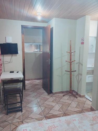 a room with a door and a table and a television at Garcia Suite 2 in Blumenau