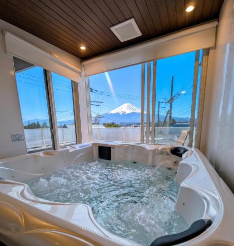 a jacuzzi tub with a view of a mountain at Kawaguchiko Villa LaLuce in Fujikawaguchiko