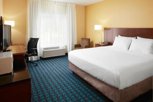 a hotel room with a large bed and a television at Fairfield by Marriott Frankfort in Frankfort
