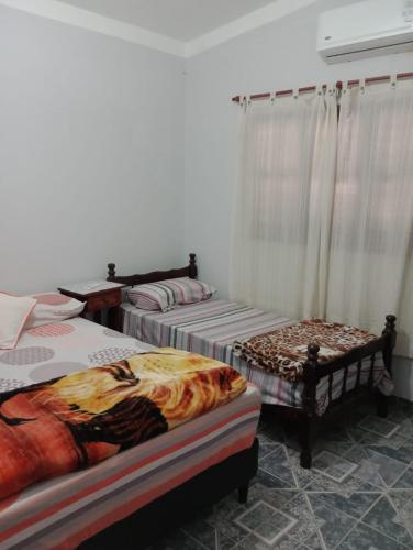 a room with three beds and a window at Alojamientos Rinconcito don Antonio casa in Tinogasta