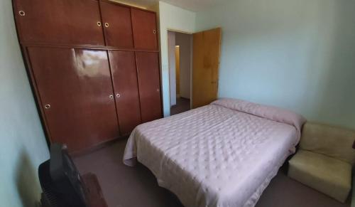 a bedroom with a bed and a cabinet and a couch at Casa en La Punta in La Punta