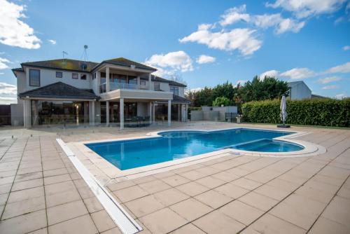 a large house with a swimming pool in a yard at Thicker Than Water Vineyard - 4 Bedroom Pool in McLaren Vale
