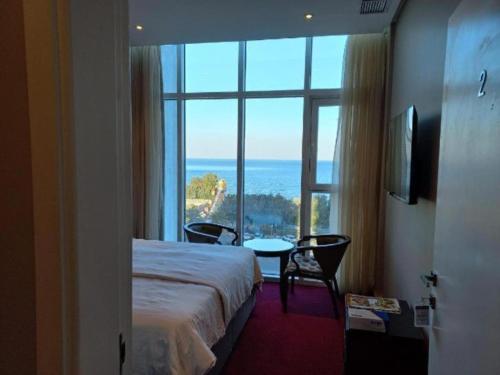 a hotel room with a bed and a large window at Bue waves in Kuwait