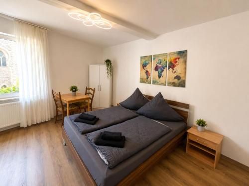 a bedroom with a large bed and a table at Zum Rheinberg Rhein Studio in Braubach