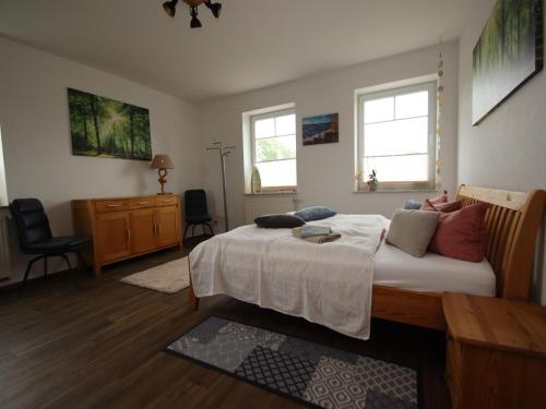 a bedroom with a large bed and two windows at Appartement im Seedomizil Kummerow in Kummerow