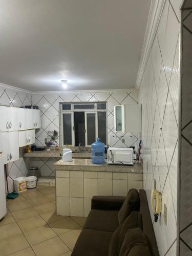 a living room with a couch in a kitchen at quarto aconchegou 1 in Divinópolis