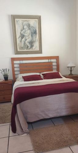 a bedroom with a large bed with a picture on the wall at Miracatu! Refúgio e Paz nas Montanhas in Miracatu