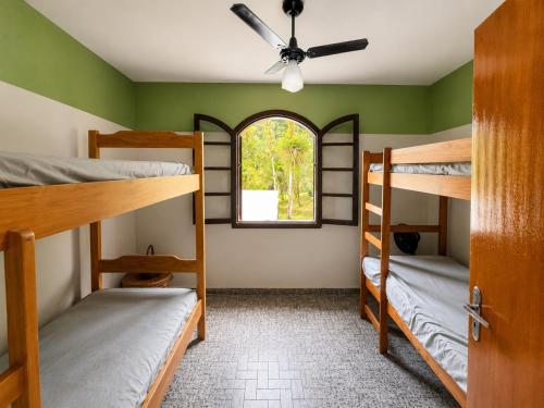 a room with four bunk beds and a window at Recanto Dom José in Peruíbe