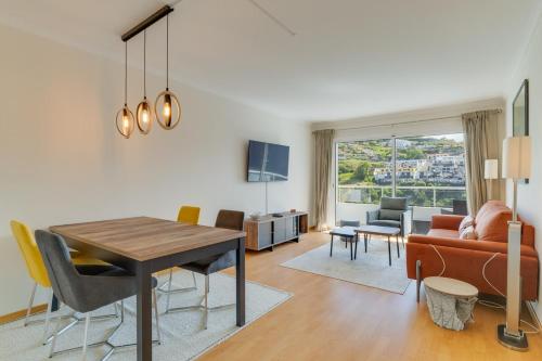 a dining room and living room with a table and chairs at Atlantic Dutchman Heated Pool & Parking in Caniço