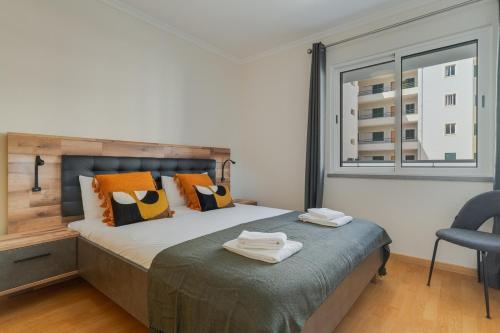 a bedroom with a bed with two towels on it at Atlantic Dutchman Heated Pool & Parking in Caniço