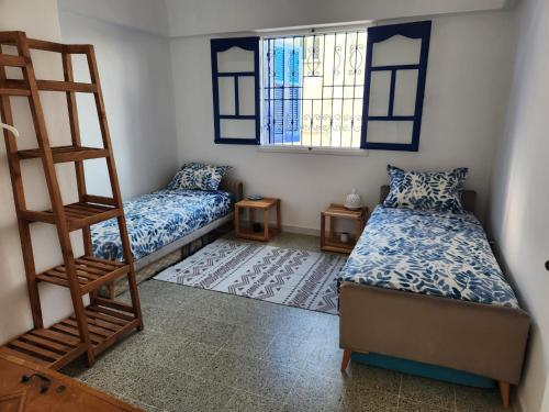 a small room with two beds and a ladder at Villa SiJoBa in Raʼs al Jabal