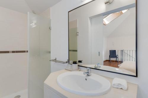 a bathroom with a white sink and a mirror at Alta Do Garajau I 5ºw in Caniço
