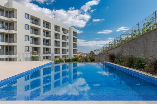 a swimming pool in front of a building at Pool Retreat For Families & Romantic Escapes in Câmara de Lobos