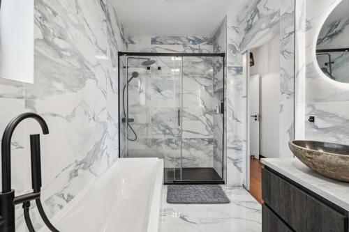 a bathroom with a tub and a sink and a shower at Casa Afonso Bay Views & Outdoor Living in Funchal