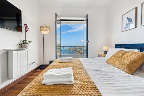 a bedroom with a large bed with towels on it at Casa Afonso Bay Views & Outdoor Living in Funchal