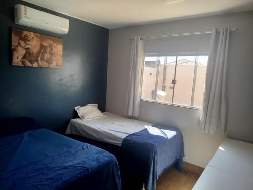 a small room with two beds and a window at Casa com Ar-Condicionado in Formosa
