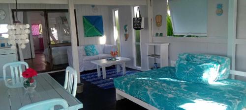 a living room with a couch and a table at Poppies Beach Bach in Matavera