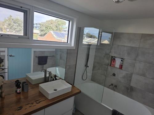 a bathroom with a sink and a tub and a shower at Zeally Bay Stay Deep Ocean in Torquay