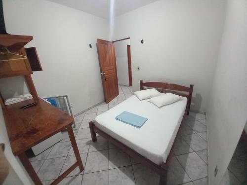 a small bedroom with a bed and a wooden table at Hotel Amaro in Luis Correia