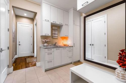 a kitchen with white cabinets and a sink at Sunnywood Garden in Richmond