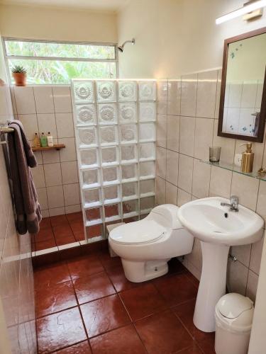 a bathroom with a toilet and a sink at Heliconia Island Lodge in Puerto Viejo