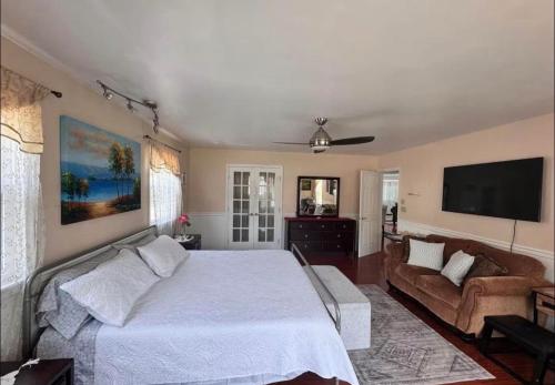 a bedroom with a bed and a couch and a flat screen tv at NinaOCPlace in Ocean City