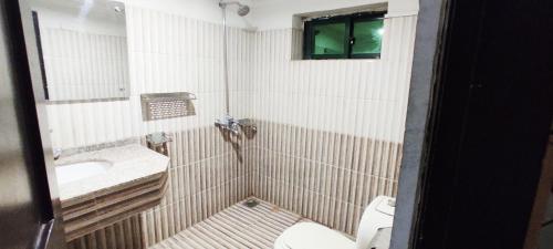a small bathroom with a sink and a toilet at The Grand Hotel Multan in Multan