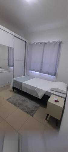 a bedroom with a large bed and a table at Quarto Privativo ao lado do Aeroporto in Sao Jose do Rio Preto