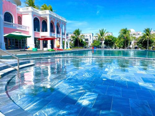 a large swimming pool in front of a building at Apple Phu Quoc Hotel & Restaurant in Phú Quốc