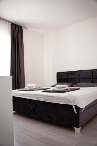 a bed in a bedroom with a black bed frame at T&M Apartman in Paraćin