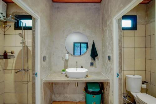 a bathroom with a sink and a mirror at Mariposa Cabin in Lembang