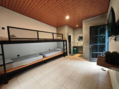 a room with two bunk beds and a bathroom at Mariposa Cabin in Lembang