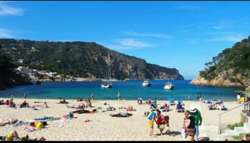 a group of people on a beach near the water at Hostal Ondina in Begur