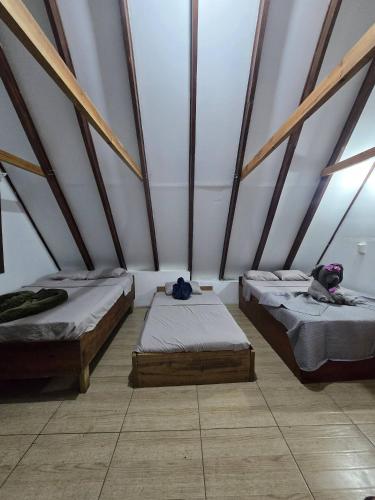 a room with two beds in a building with beams at private and pleasant in Zapotal