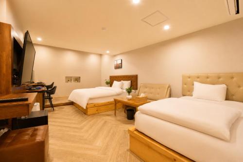 a hotel room with two beds and a television at 경산 에비앙 호텔 in Uksu
