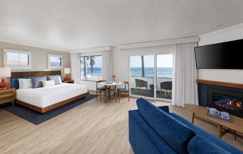a hotel room with a bed and a fireplace at Sandcastle Hotel on the Beach in Pismo Beach