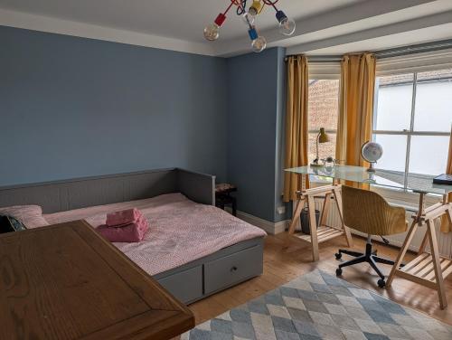 a bedroom with a bed and a desk and a table at Rusthall Prospect House in Speldhurst