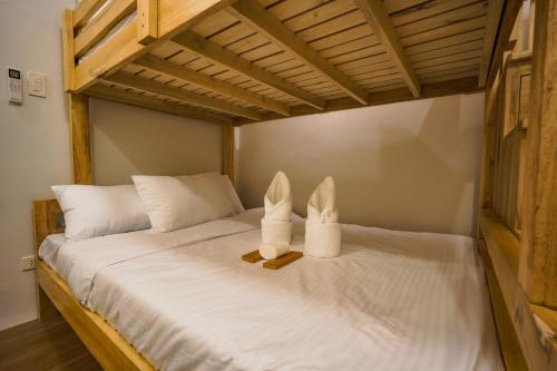 a bed with two bunny towels on top of it at Ikigai Narvacan Hometel in Narvacan