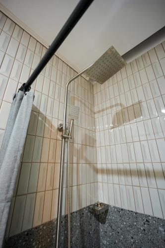 a bathroom with a shower with a shower curtain at Ikigai Narvacan Hometel in Narvacan