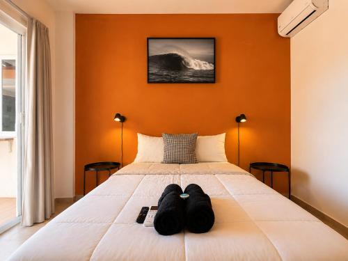 a bedroom with a bed with two black shoes on it at La Aurora Puerto Escondido in Puerto Escondido
