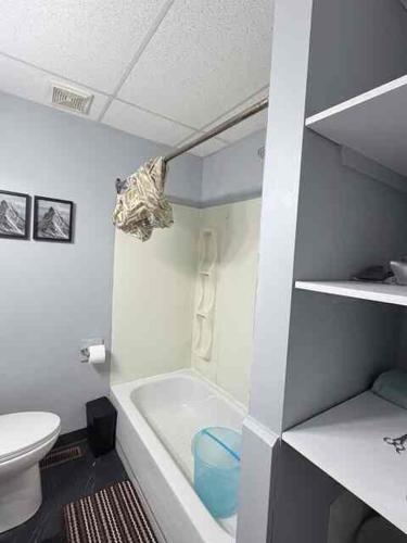 a bathroom with a toilet and a tub and a sink at 2806 Regina in Regina
