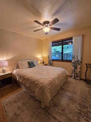 a bedroom with a bed and a ceiling fan at Hale Mauna Loa Upper Level with shared Hot Tub in Volcano