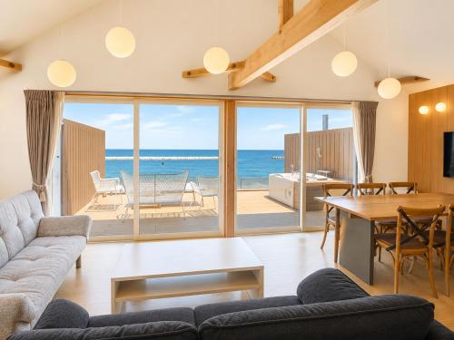 a living room with a view of the ocean at Beach SPA TSUDA 0 Cero棟 in Sanuki