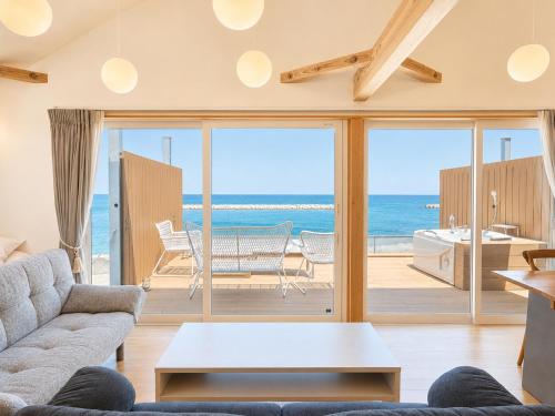 a living room with a view of the ocean at Beach SPA TSUDA 0 Cero棟 in Sanuki
