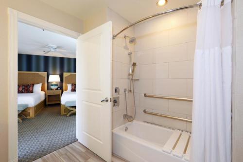 a bathroom with a tub and a shower with a shower curtain at Spyglass Inn in Pismo Beach