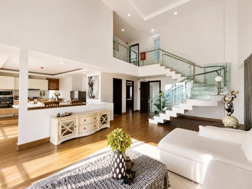 a living room with a white couch and a staircase at Sopor Resident in Phnom Penh
