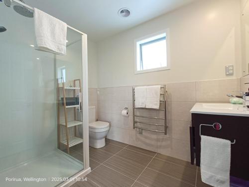 a bathroom with a shower and a toilet and a sink at Waterview Spacious Bliss - 2 Beds in Porirua
