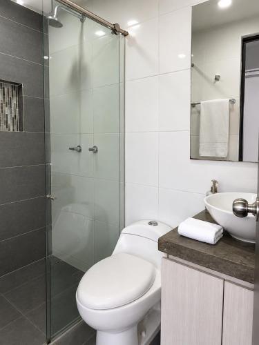 a white bathroom with a toilet and a sink at Lovely Private Apto in Poblado in Medellín