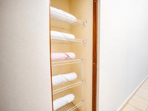a closet with white towels and a mirror at Arenales Guest House in Isabela